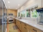 Outdoor kitchen has dishwasher, full gas range, convenience store refrigerator opens to bar area
