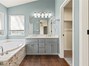 Primary bathroom with jetted tub, dual sinks, walk-in closet and walk-in shower.