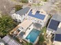 Drone view of home showing pool and solar.
