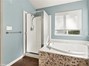 Primary bathroom with jetted tub and walk-in shower.