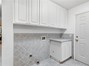 laundry area adjacent to bathroom with abundance of storage