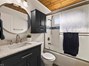 Stylish updates meet original charm with a modern vanity, decorative tile, and warm wood ceiling!