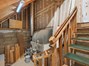 Stairs to basement area with wood burning furnace.