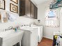 Inside laundry room with cabinets and sink.