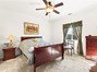 Primary bedroom with ceiling fan and window overlooking backyard.