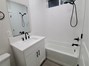 View of master bath with shower/tub combo, sink vanity & toilet.