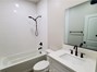 View of guest bathroom with shower/tub combo.