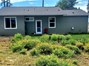View of back of house with landscaped backyard.